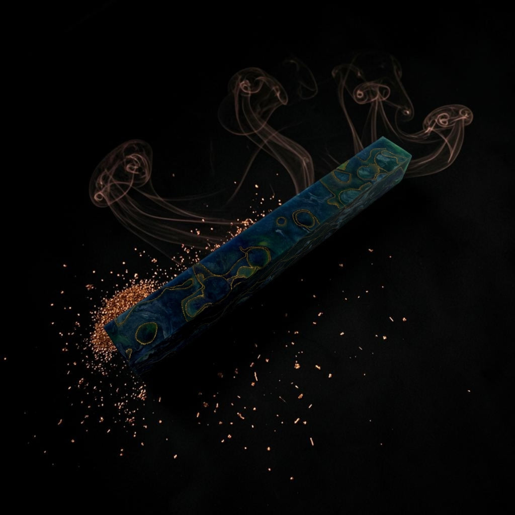 Resin pen blank  resin bead blank  pen making material A  rectangular blue and green marbled crystal wand or amulet lies diagonally on a black background, with fine metallic copper powder scattered near one end and wispy smoke rising from the other. No person, animal, or real environment is present, so this is Product/Packaging rather than Lifestyle.