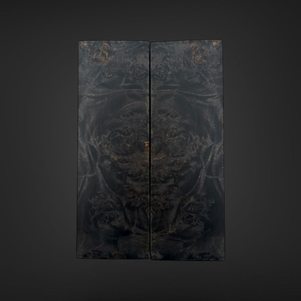 Male Burl knife scales. A dark, double-panel folding screen or decorative wall art piece featuring an intricate, low-contrast black and charcoal pattern with subtle warm metallic-looking highlights, centered against a dark gray gradient background.